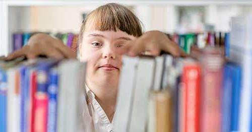 A student looking through books as part of her special education online.